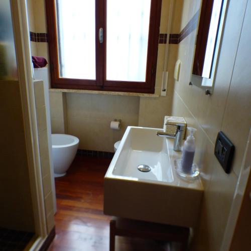 a bathroom with a sink and a toilet and a window at Girasoli in Pisa