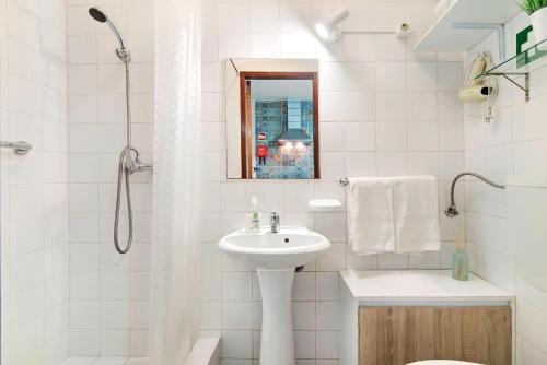a white bathroom with a sink and a shower at A Casa dos Avós in Pêra