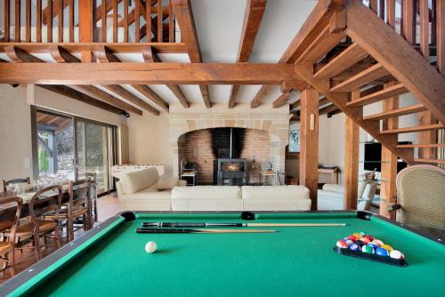 a living room with a pool table in a room at Domaine du Segala in Bagnac