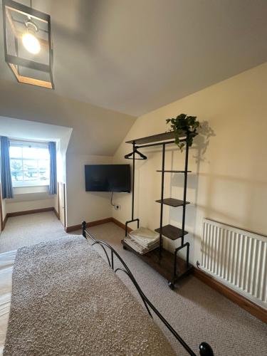 a room with a bed and a tv and a shelf at Riverside in Brecon