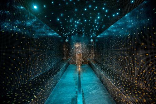 a dark room with a pool of water and lights at SWISSPEAK Resorts Vercorin in Vercorin