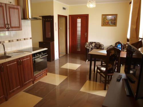 a kitchen with a table and a stove top oven at Hotel Willa Park in Żagań