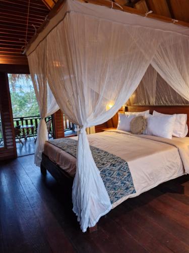 a bedroom with a bed with a mosquito net at The Sanctuary - Private pool villas in Gili Air