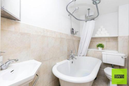 a white bathroom with a sink and a toilet at Modern 2 Bedroom with Free Parking & near Tube in London