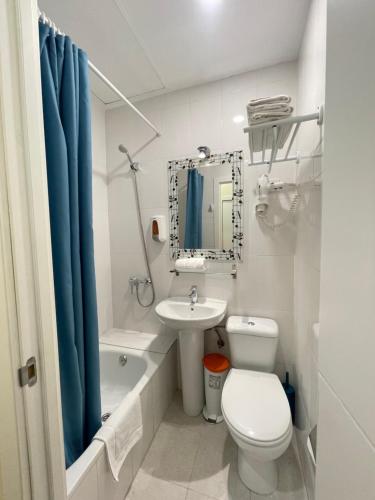 La salle de bains est pourvue de toilettes blanches et d'un lavabo. dans l'établissement Hostal Oliver, à Madrid