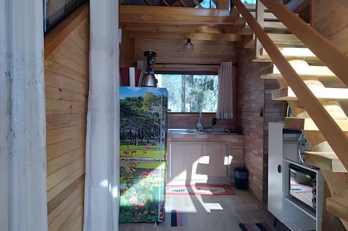eine Küche mit Holzwänden und eine Treppe in einem Haus in der Unterkunft Cabana Pequeno Bosque com deck e vista p/ o rio in São Joaquim