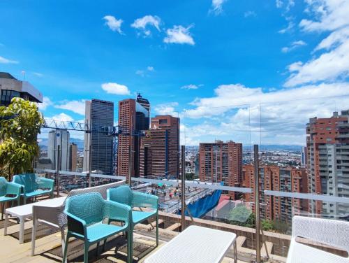 a balcony with chairs and a view of a city at The Equilibrium Collection in Centro Internacional in Bogotá