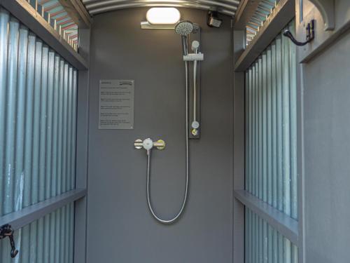 een douche in een kamer met 2 ramen bij YHA Windermere in Troutbeck
