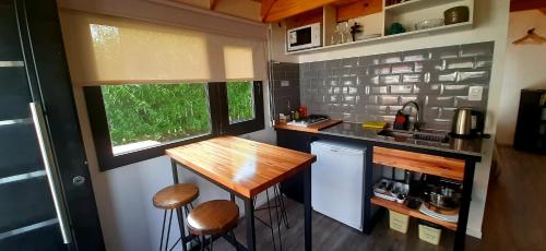 una cucina con tavolo e sgabelli in una casetta minuscola di Patagonia Tiny House a El Chalten