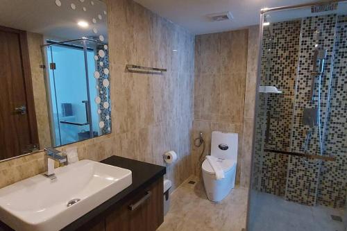 芭達雅中心的住宿－Grand Avenue, Luxury Suite, 72sqm pool view with lounge area，一间带水槽、淋浴和卫生间的浴室