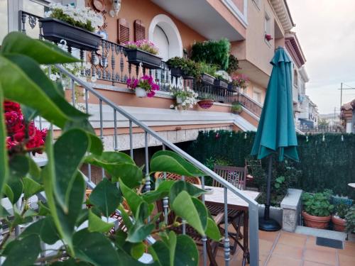 un balcone con piante e ombrellone di Casa La Montaña a Las Navas del Marqués