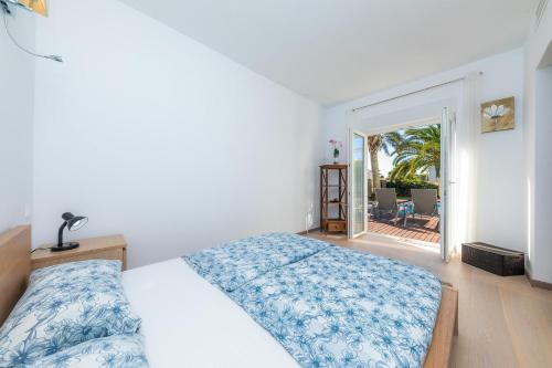 a bedroom with a bed and a view of a patio at Villa Amarador in Santanyi