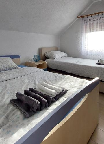 a bedroom with two beds with towels on the bed at Kuća za odmor Boki in Gospić