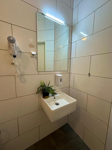 a white bathroom with a sink and a mirror at Bern Boutique by Rikas Hotels in Tallinn