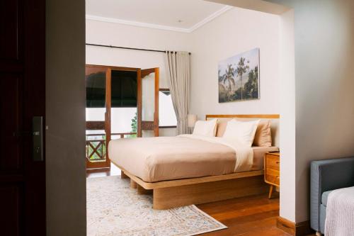 a bedroom with a large bed and a window at Girihill Farmhouse in Munduk