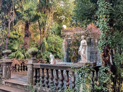 a statue on a fence in a garden at Dimora storica, appartamento in Villa Pampinuccia in Bassano del Grappa