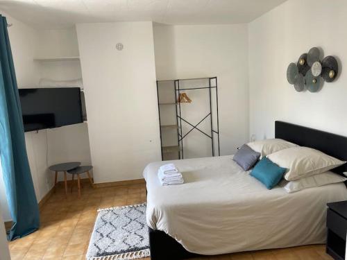 une chambre avec un grand lit blanc avec des oreillers bleus dans l'établissement Eiffel Tour Cosy blue, à Paris