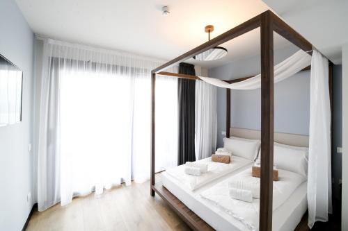 リモーネ・スル・ガルダにあるHotel Villa Dirceのベッドルーム(白い枕の天蓋付きベッド1台付)