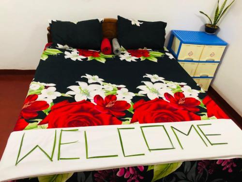 a bed with red roses and a welcome sign on it at Bole Guest Bentota in Bentota