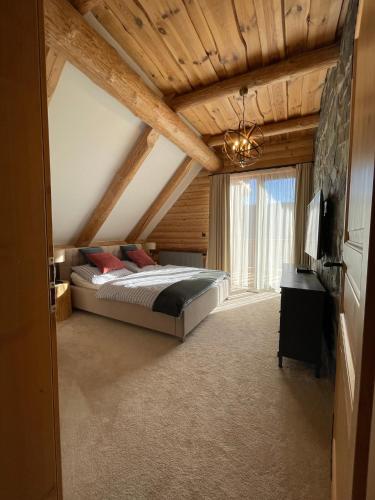 a bedroom with a bed and a large window at Zrub Mrázik in Veľká Lomnica