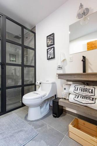 a bathroom with a white toilet in a room at La Fábrica #7 Averly in Valle de Bravo