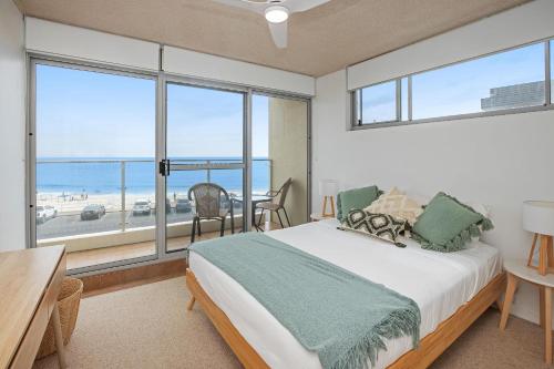 Un dormitorio con una cama con vista al mar. en Oceanic 7, en Forster