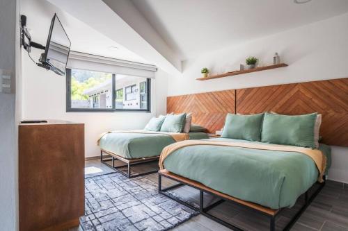 una camera da letto con due letti e una finestra di La Fábrica #7 Averly a Valle de Bravo