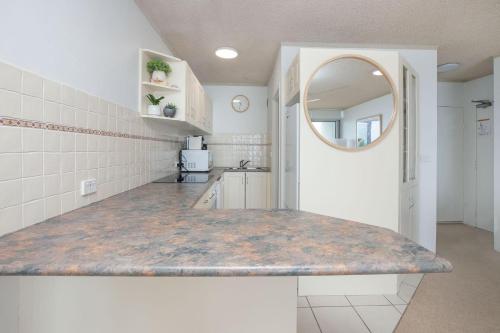 una cocina con encimera y espejo en Oceanic 7, en Forster