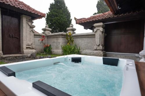 a hot tub in the backyard of a house at Girihill Farmhouse in Munduk