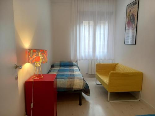 een kleine slaapkamer met een bed en een stoel bij Ponte di Cecco appartamenti in Ascoli Piceno