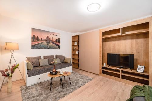 a living room with a couch and a tv at Central Athena Studio - Inima Pieței Unirii - By OpenHouse apartments in Timişoara