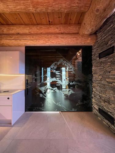 a kitchen with a wall with a painting on it at Zrub Mrázik in Veľká Lomnica