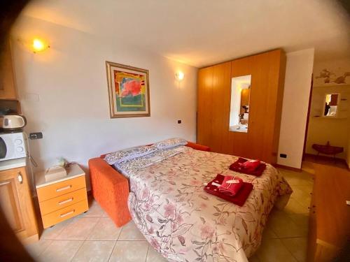 1 dormitorio con 1 cama con 2 toallas rojas en Betty bu, en Caspoggio