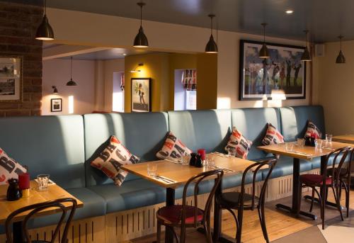 uma sala de jantar com mesas e cadeiras num restaurante em Sugarbeat Eating House em Norwich