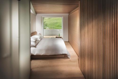 um quarto com uma cama grande e uma janela em House of Architects em Vals