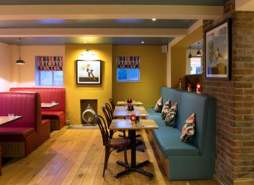 a dining room with a table and a bench at Sugarbeat Eating House in Norwich