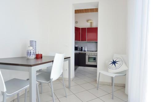 - une cuisine blanche avec une table et des chaises blanches dans l'établissement Trilo_Mina 3, à Cattolica