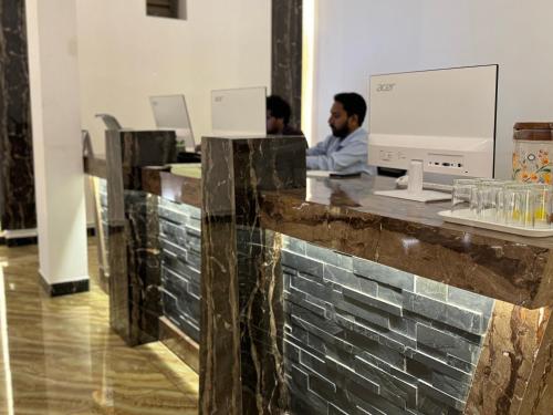 two men sitting at a counter in an office at La Antilia Luxury in Puducherry