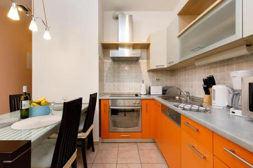 a kitchen with orange cabinets and a counter top at Apartman Z in Split