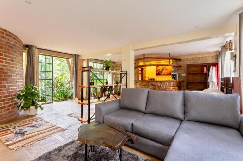 a living room with a couch and a brick wall at The Jungle Oasis with heated pool in Nairobi