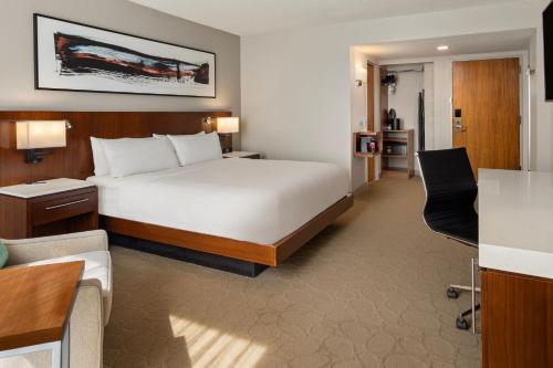 ein Hotelzimmer mit einem Bett und einem Wohnzimmer in der Unterkunft Delta Hotels by Marriott Minneapolis Northeast in Minneapolis