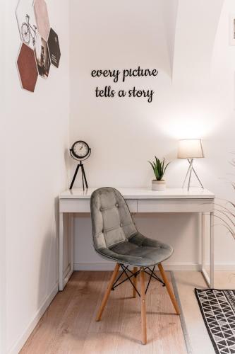 a desk with a chair and a desk with a sign that reads every picture tells at Central Athena Studio - Inima Pieței Unirii - By OpenHouse apartments in Timişoara