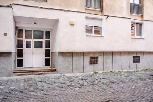 a building with a white door and a brick street at Central Athena Studio - Inima Pieței Unirii - By OpenHouse apartments in Timişoara