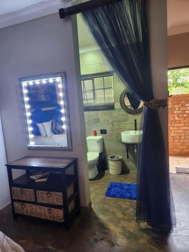 a bathroom with a mirror and a sink at Suikerbosrant Sleep and go in Pretoria