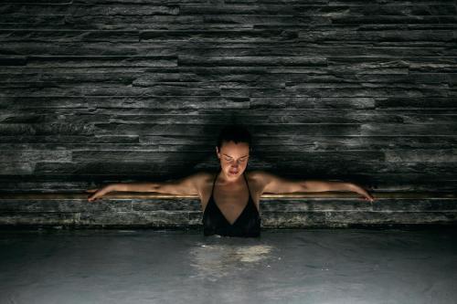 a man in the water with his arms out at House of Architects in Vals