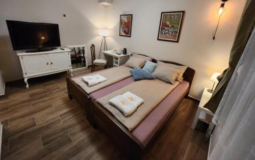 a bedroom with a large bed with a flat screen tv at RoomsApartments PopCOURT in Pančevo