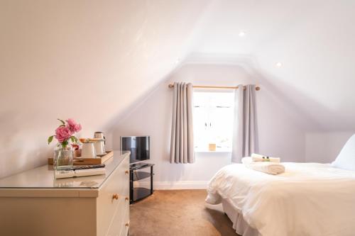 a white bedroom with a bed and a window at Sugarbeat Eating House in Norwich