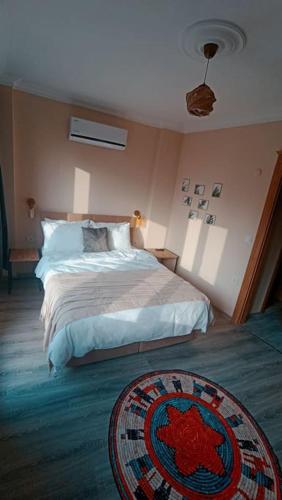 a bedroom with a bed and a rug on the floor at Deniz Manzaralı Müstakil ev Aybalik in Ayvalık