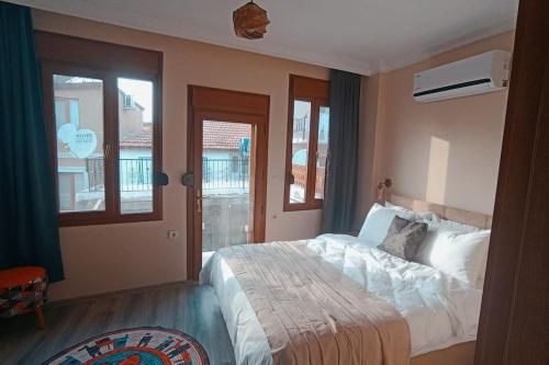 a bedroom with a large bed and windows at Deniz Manzaralı Müstakil ev Aybalik in Ayvalık