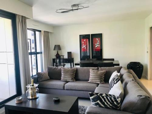 un salon avec un canapé et une table dans l'établissement Charmant 2 pcs + Parking + Balcon + 1 min plages, à Cannes